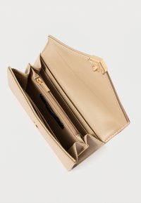 Beige portemonnee van kunstleer met een gestructureerde afwerking, voorzien van een goudkleurige sluiting, meerdere vakken en een binnenvak met rits.