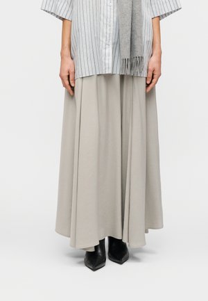 Maxi skirt in light grey fabric with a smooth texture. Paired with a button-up striped shirt and black pointed-toe ankle boots.