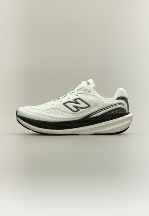 Бяло и черно спортно обувки с дебела подметка и лого на New Balance отстрани, показани на неутрален фон.