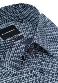 Granatowa koszula w wzory z białymi diamentami, wąski krój, z detalami guzików i kontrastowym kołnierzykiem. Widoczna metka marki wewnątrz.