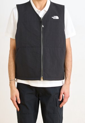 Gilet nero senza maniche con zip frontale, realizzato in tessuto testurizzato; presenta due tasche anteriori e un piccolo logo sulla parte superiore del petto sinistro.