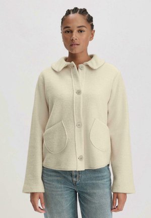 Cremefarbene Wollmischjacke mit runder Kragen, zwei großen Fronttaschen und Knopfverschluss; weiche Textur, lässige Passform.