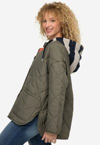 Giacca trapuntata verde oliva con cappuccio a strisce blu e beige. Presenta grandi tasche laterali e un design dalla vestibilità comoda.