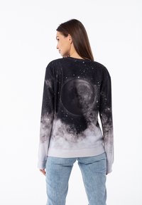 Felpa nera e grigia con grafica della luna, caratterizzata da un design di cielo stellato e texture morbida. Collo rotondo e maniche lunghe.