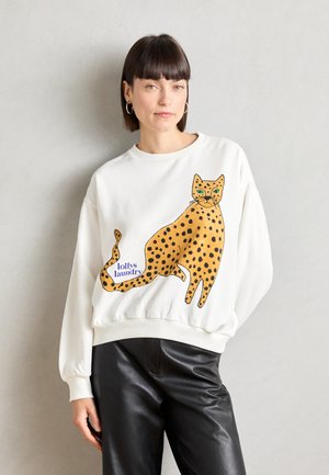 Hanorac alb cu un design mare de leopard cu pete portocalii și negre pe față și textul "lolly’s laundry". Material moale, croială lejeră.