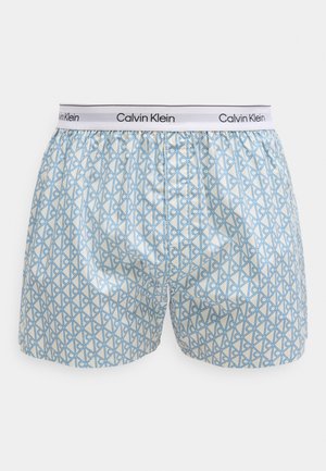Boxers pour hommes avec motif géométrique bleu, taille élastique blanche marquée du logo Calvin Klein en noir.