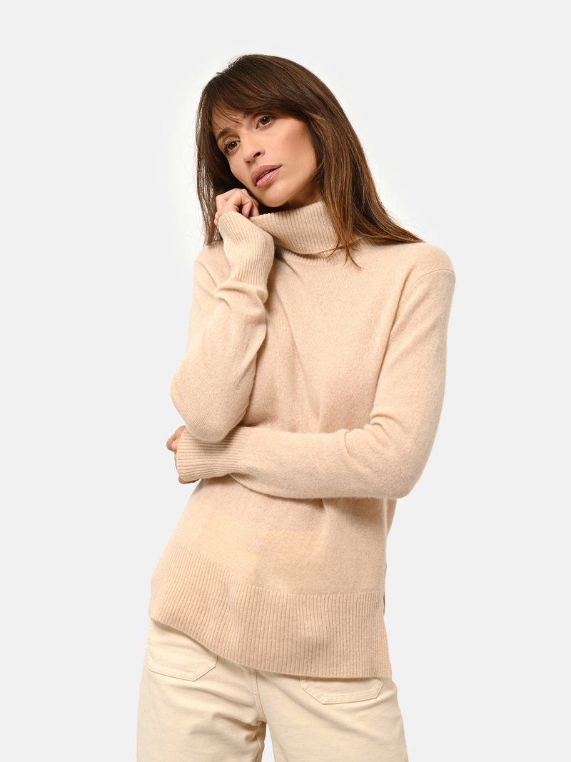 Pull beige a collo alto in morbido filato, con polsini e orlo a coste. Il design presenta una vestibilità ampia con uno schienale leggermente più lungo.