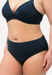 Marinblå bomullsbH med spetsdetaljer upptill och mjukt bygelfoder, matchande med högmidjade trosor med en liten rosett.