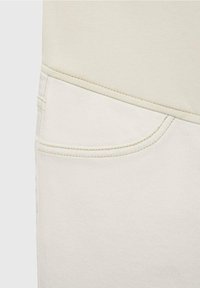 Jeans in denim beige chiaro con dettagli sulle tasche e cuciture color crema. Il tessuto ha una texture liscia ed è aderente.