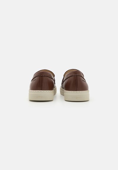 Baskets en cuir marron avec une finition lisse, design sans lacets et semelle en caoutchouc crème. Accents festonnés le long du bord supérieur.