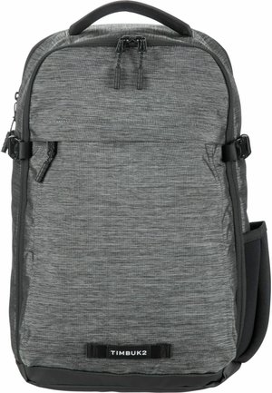 Sac à dos gris avec une finition en tissu texturé, compartiment principal à double zip, poche latérale et un panneau en plastique au fond pour plus de durabilité.