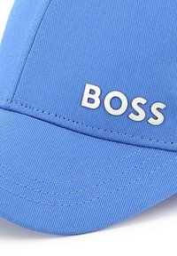 Blauwe baseballcap van gestructureerde stof met een gebogen rand. Voorzien van het witte "BOSS"-logo aan de voorkant en contrasterende stikseldetails.