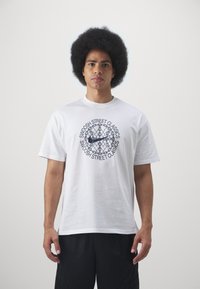 Witte katoenen T-shirt met korte mouwen, uitgerust met een circulair marineblauw grafisch ontwerp en tekst die "SWOOSH STREET CLASSICS" in een vette lettertype weergeeft.