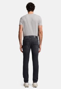 Donkerdenim jeans met een rechte pasvorm, vijf zakken en een zachte textuur, gecombineerd met een grijze ronde hals t-shirt en sneakers.