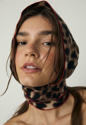 Sciarpa con stampa leopardata dal taglio aderente, realizzata in tessuto morbido, con bordi rossi, versatile per essere indossata in testa o attorno al collo, con un aspetto testurizzato.