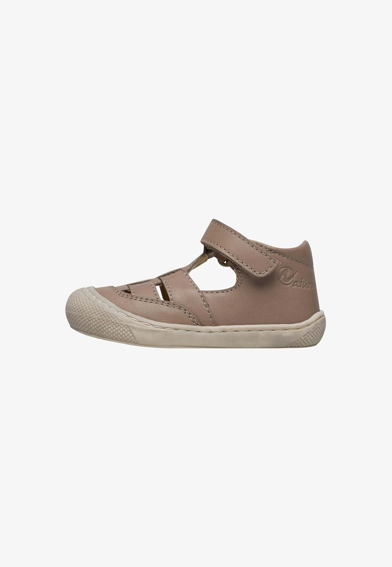 Chaussure pour enfant en cuir marron avec des découpes et une bande Velcro. Semelle en caoutchouc blanche avec un bout texturé. Conception à chevilles basses.