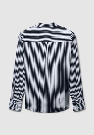 Maglietta a maniche lunghe a righe in bianco e nero, con yoke posteriore, dettagli a pieghe e polsini abbottonati con accenti a righe coordinati.