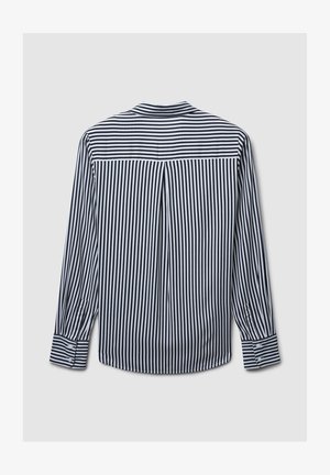 Maglietta a maniche lunghe a righe in bianco e nero, con yoke posteriore, dettagli a pieghe e polsini abbottonati con accenti a righe coordinati.