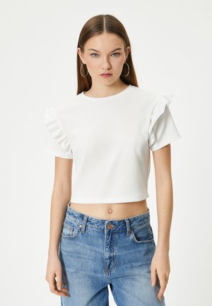 Witte cropped t-shirt met gerimpelde mouwen, gestructureerde stof, ronde halslijn, gecombineerd met high-waisted blauwe denim jeans.