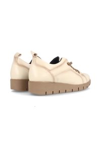 Zapatillas de cuero beige con punta redondeada, suela de goma texturizada marrón y cordones beige a juego. Presenta un pequeño tirador trasero.