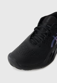 Melnas sporta kurpes ar teksturētu sintētisku augšdaļu, sasaistes sistēmu un violetu akcentu sānos. Apaļa purngala un mīksts zole.