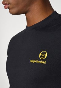 Black cotton sweatshirt featuring a ribbed neckline and a golden embroidered logo with text on the left chest area.