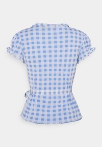 Modrá a bílá kostkovaná blůza s krátkými volánkovými rukávy, peplum lemem a zavazovací detaily v pase. Lehce vzdušná textilie.