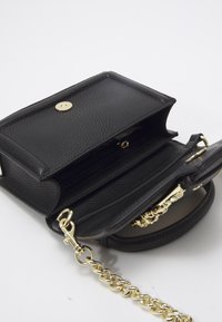 Borsa in pelle nera con texture, dotata di tracolla a catena dorata, con pattina aperta che mostra una tasca interna con zip e chiusura dorata su sfondo bianco.