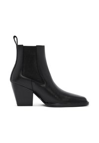 Botas Chelsea negras de cuero con un panel lateral elástico texturizado, punta redondeada y tacón cuadrado. Cuenta con una lengüeta para facilitar el calzado.