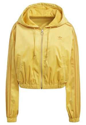 Gele corduroy cropped jas met capuchon, voorrits, trekkoord capuchon, zijzakken, elastische zoom en Adidas-logo op de borst.