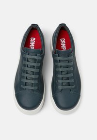 Sneakers in pelle verde petrolio scuro con suole in gomma bianca e lacci abbinati, caratterizzati da una finitura testurizzata e solette rosse con logo "Camper".