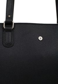 Borsa a tote in pelle nera con texture, due manici e elementi in metallo argentato. La superficie presenta una finitura a ciottoli, che enfatizza durata e stile.