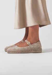 Espadrilles de ante beige con una correa de tipo Mary Jane, que presentan una punta redonda, suela de yute trenzado y un acento de hebilla en tono dorado.