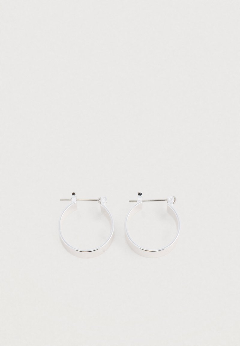 Srebrne kolczyki w kształcie kółek o polerowanym wykończeniu, z prostym okrągłym kształtem i zapięciem na sztyft, zapewniającym bezpieczne noszenie.