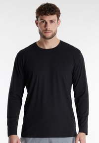 Schwarzes Langarm-T-Shirt aus glattem Baumwollstoff; mit Rundhalsausschnitt und normaler Passform. Einfaches Design ohne Muster oder Akzente.