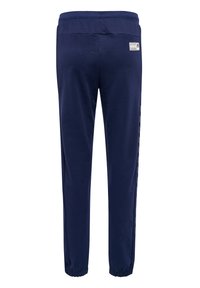 Marineblauwe joggingbroek met een elastische tailleband, taps toelopende benen en enkelboorden; bevat een reflecterende logodetail aan de achterkant.
