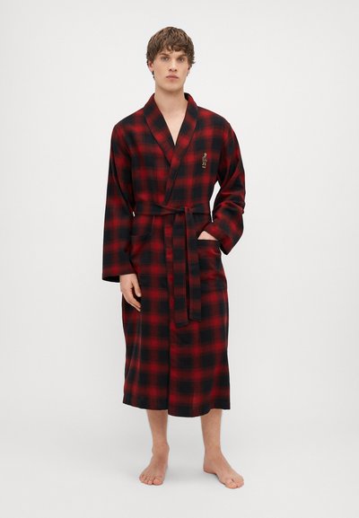 Juodas ir raudonas plaid miegamoji chalatą su ilgomis rankovėmis, surišamu diržu ir šoniniais kišeniais. Audinys atrodo minkštas ir jaukus, tinkamas poilsiui.