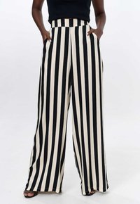 Zwart en crème gestreepte wijde broek met een hoge taille en zijzakken, met een zachte stof textuur.