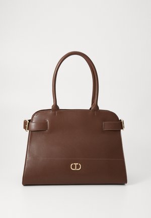 Sac à main en cuir marron avec des poignées arrondies, des détails de boucle en or sur les côtés et un petit emblème de logo doré centré sur le devant.