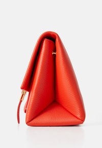 Borsa a tracolla triangolare rossa in pelle con superficie texturizzata, design piegato, accessori in metallo dorato e una piccola tracolla laterale. Forma compatta e strutturata.