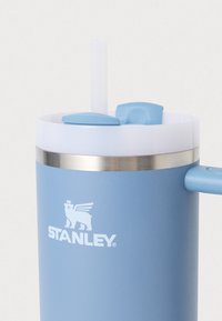 Matt kék színű rozsdamentes acél pohár fehér fedéllel, szívószállal és kék szeleppel. A STANLEY logó fehér színben látható rajta.