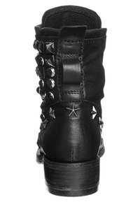 Černé kotníkové boty s texturovanou tkaninou a kůží, zdobené kovovými hroty a hvězdnými akcenty na straně, s nízkým dřevěným podpatkem.