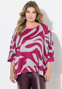 Top in stampa animale magenta e grigia con vestibilità ampia, maniche larghe e scollatura rotonda, abbinato a leggings in ecopelle nera.