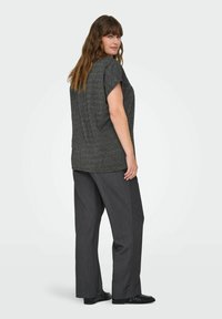 Haut gris à manches courtes avec une finition texturée, associé à un pantalon large gris foncé. Tissu lisse et design à coupe ample.