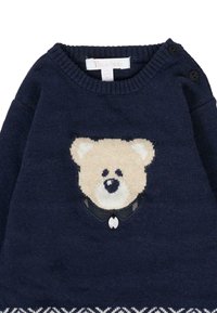 Granatowy dziergany sweter z beżowym haftem przedstawiającym twarz niedźwiedzia, czarnymi akcentami na kołnierzu i białym wzorem na dole. Guziki na ramieniu.