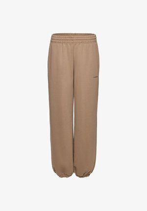 Beežid lahtised dressipüksid elastse vöö ja sääreotsadega, peal väikese ja kuiva logotekstiga.