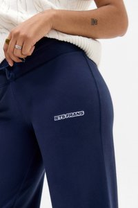 Navy modre trenirke iz mešanice bombaža, ki imajo izvezen logo "LETS FRANS" na stegnu in elastičen pas s vrvico.