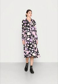 Vestido de mangas longas em tecido preto com flores rosas e roxas. Apresenta um botão frontal e uma saia midi rodada.