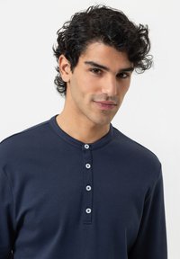 Navy Langarm-Henley-Shirt aus weichem Stoff, mit einem runden Kragen und einer Knopfleiste mit vier kontrastierenden Knöpfen.