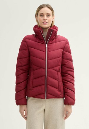 Rode gewatteerde jas met ritssluiting, hoge kraag en chevron-quilting. Voorzien van zijzakken en ribgebreide manchetten voor extra warmte.